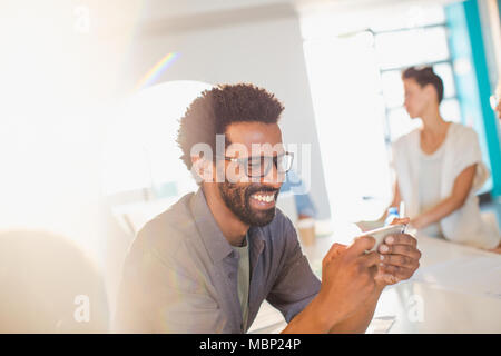 Smiling businessman using smart phone Stock Photo