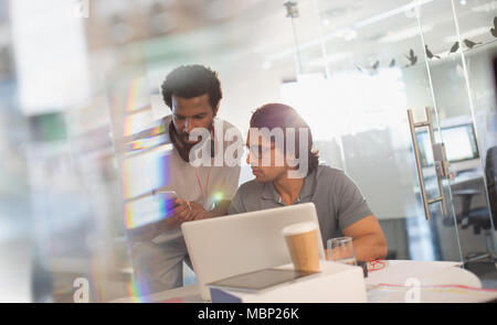 Creative businessmen working at laptop, using smart phone in office Stock Photo