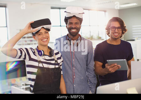 Portrait smiling, confident computer programmers testing virtual reality simulators in office Stock Photo