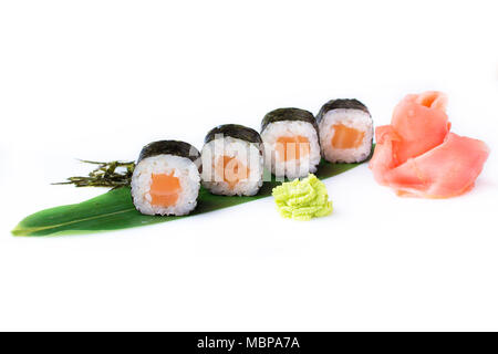 Delicious fresh mini-rolls with salmon on a banana leaf. Sushi rolls on a white background with ginger and wasabi. The Japanese menu. Stock Photo