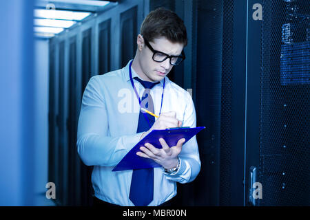 Concentrated operator taking important notes Stock Photo