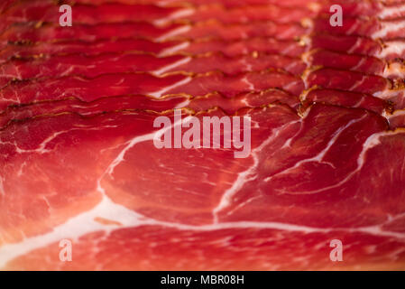 Sliced italian prosciutto background. Top view, copy space. Prosciutto texture close up. Stock Photo