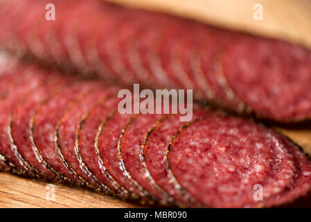 Macro of smoked salami sausage background. Top view, copy space. Sliced salami texture close up Stock Photo