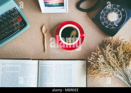 A cup of coffee with typewriter , alarm clock , telephone , notebook . top view image Stock Photo