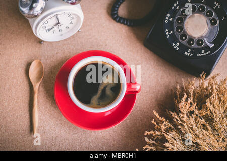 A cup of coffee with typewriter and alarm clock  and book on table Stock Photo