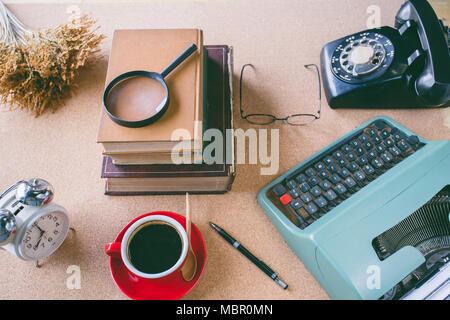 A magnifying glass on stack book with accessories retro office  on table Stock Photo