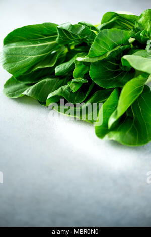 Green organic bok choy chinese cabbage on grey concrete background. Copy space, top view, flat lay Stock Photo