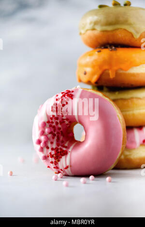 Sweet and colourful doughnuts on grey background. Fresh baked donuts. Copy space. Stock Photo