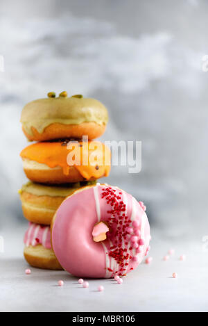 Sweet and colourful doughnuts on grey background. Fresh baked donuts. Copy space. Stock Photo