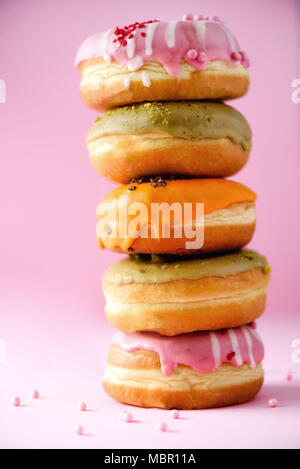 Sweet and colourful doughnuts on pink background. Fresh baked donuts. Copy space. Stock Photo