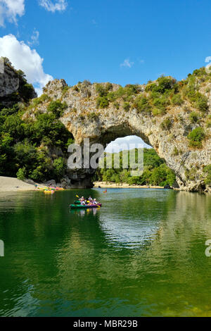 Canoeing past the natural stone arch of Pont d Arc in the Gorges