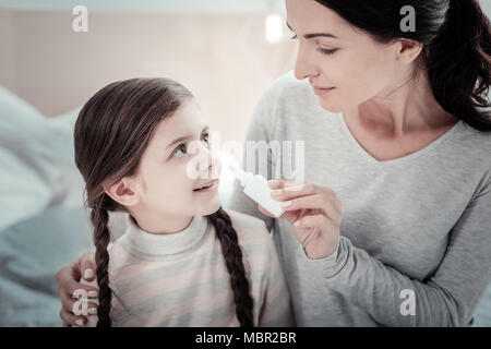 Pleasant cute girl smiling and looking at her mother. Stock Photo