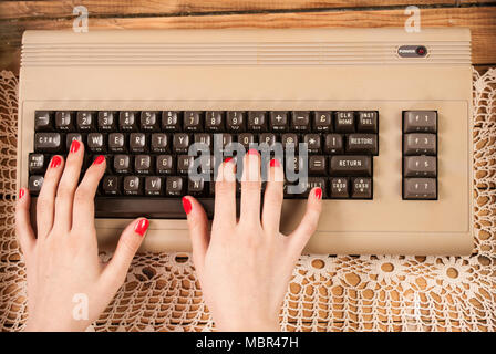 Woman working on old computer keyboard Stock Photo