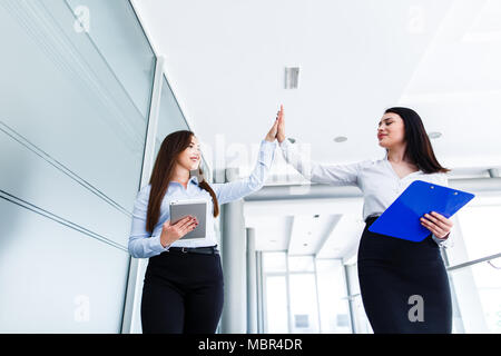 Business womens doing high five in modern interior Stock Photo