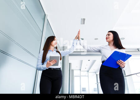 Business womens doing high five in modern interior Stock Photo