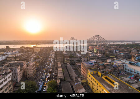 Aerial view of Kolkata city, India. Beautiful sunset over the famous Howrah bridge - The historic cantilever bridge on the river Hooghly, Calcutta, In Stock Photo