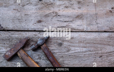 Old rusty vintage tools for handmade hammers lie on the old wooden table. Copy space, Stock Photo