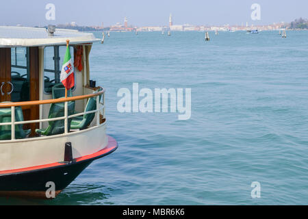 Flag of Italy on foreground of Venetian Lagoon with the historic centre of Venice in the background. Stock Photo