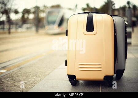 Citypass Light Rail in Jerusalem. Two suitcases standing on railway station against city train. Vacation and travel concept. Copy space, selective focus Stock Photo