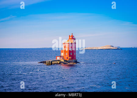 Outdoor view of the red lighthouse on the Norwegian sea over a rock Stock Photo