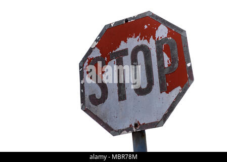 Old weathered stop sign with peeling paint isolated on white background, slanted traffic sign Stock Photo