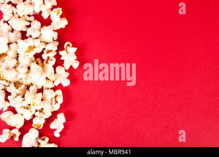Popcorn on red background with empty space, top view Stock Photo