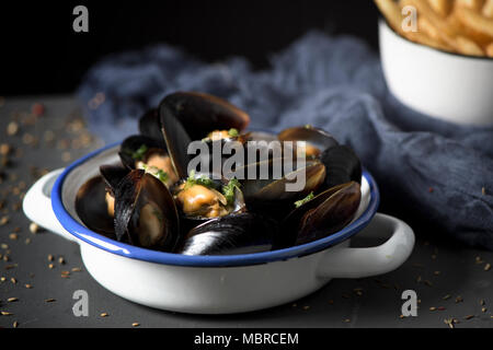 moules-frites, mussels and fries typical of Belgium, on a rustic wooden table Stock Photo