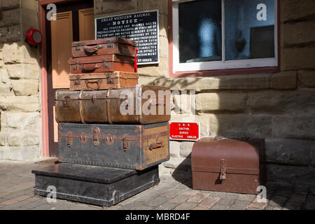 Landscape shot of 1940s wartime luggage display (period artefacts) on platform of heritage railway station. Vintage suitcases, trunks, relics of past. Stock Photo