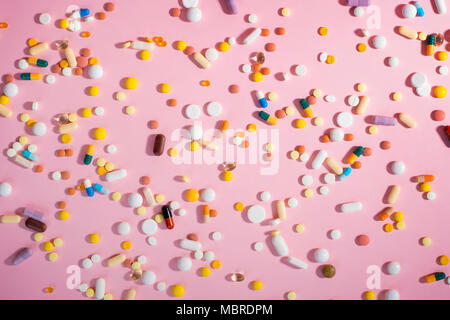 Background with medicines, pills, supplements and vitamins tablets on pink background. Stock Photo