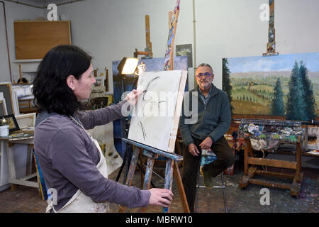 female painter makes a portrait of a man Stock Photo