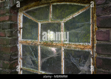 Vintage window of a stable with cobwebs and dirt in the Netherlands, Europe Stock Photo