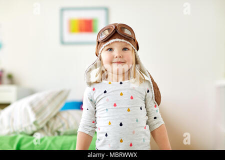 happy little girl in pilot hat playing at home Stock Photo