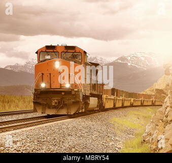 Long freight train moves through Canadian Rockies. Stock Photo
