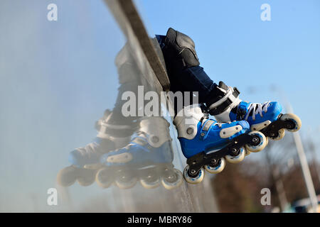 Feet of of group childrens wearing inline roller skates sitting in outdoor skate park, Close up view of wheels befor city race for healthy and active  Stock Photo