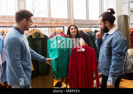 friends choosing clothes at vintage clothing store Stock Photo