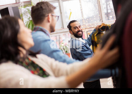 friends choosing clothes at vintage clothing store Stock Photo