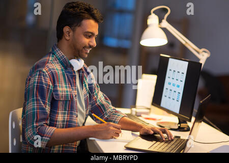 creative man with laptop working at night office Stock Photo