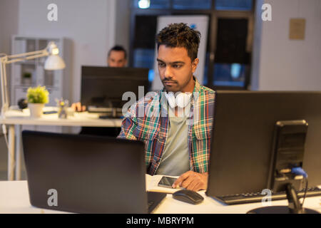 creative man with laptop working at night office Stock Photo