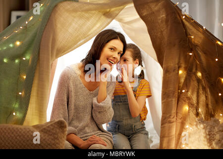 happy family whispering in kids tent at home Stock Photo