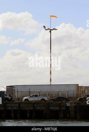 Light pole with a wind sock on top and the Smith Cove waterway ship terminal in Seattle. Stock Photo