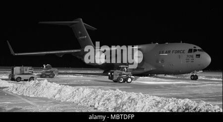 Maintenance personnel from the 736th Aircraft Maintenance Squadron use Bobcats to clear snow around a C-17A Globemaster III, Jan. 5, 2018, at Dover Air Force Base, Del. The 436th Operations Support Squadron weather flight recorded eight inches of snow fell on the base from Winter Storm Grayson. (U.S. Air Force photo by Roland Balik) Stock Photo