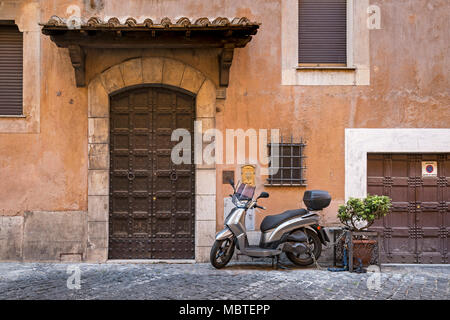 Is the front door big or the garage door small? A residential street in Rome, Italy, the facade of a villa with weathered exterior in shades of terrac Stock Photo