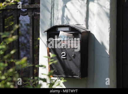 Old mailbox with newspaper on the wall Stock Photo