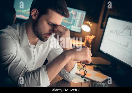 Tired businessman suffers from computer vision syndrome taking off glasses massaging eyes working late, fatigued trader feels eyestrain, has bad blurr Stock Photo