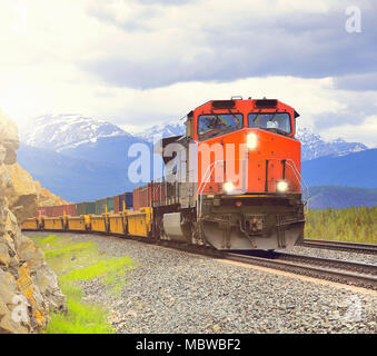 Long freight train moves through Canadian Rockies. Stock Photo