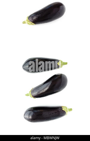 Closeup of four whole purple eggplants with water drops on white background. Top view. Stock Photo