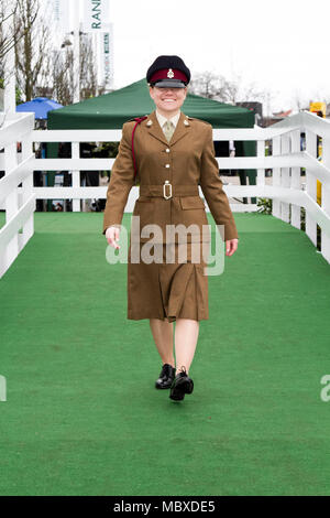 British army female soldier; Smart Cheryl Hill of the Queens Own Regiment at the most famous event in the horse racing calendar welcomes people on this very special parade of Ladies outfits & the finest female fashions.  Racegoers have been urged to 'smarten up' to make the event more ‘aspirational’ as thousands of glamorous women pour through the entry gates on the one and only 'Grand National' as up to 90,000 visitors are expected to attend the spectacular National Hunt Racing event. Stock Photo