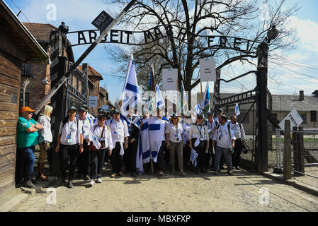 Oswiecim, Poland. 12th Apr, 2018. Participants wave Israeli flags at the main gate of the former Nazi German Auschwitz-Birkenau death camp during the 'March of the Living' at Oswiecim. The annual march honours Holocaust victims at the former Nazi German Auschwitz-Birkenau death camp in southern Poland. Credit: Omar Marques/SOPA Images/ZUMA Wire/Alamy Live News Stock Photo