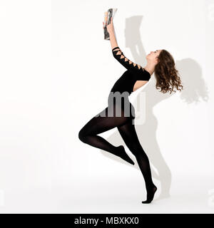 Young ballerina reading magazine , standing on one leg Stock Photo
