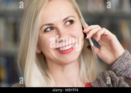 Young Beautiful Student Talking Phone While Preparing for Exams in Univercity Library Stock Photo